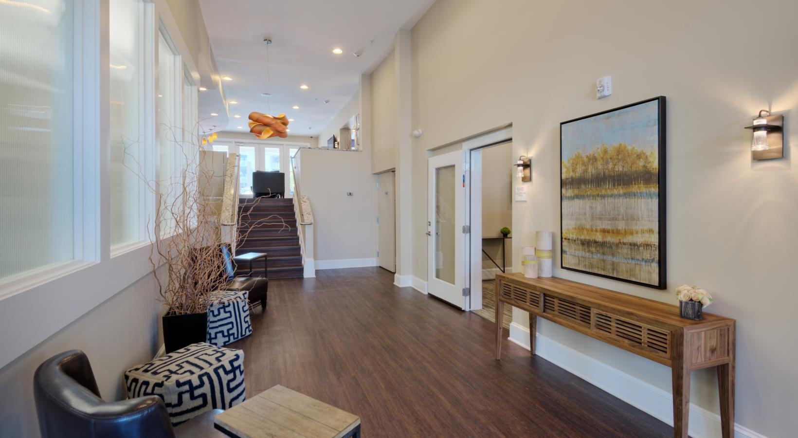 Cutting-edge amenities at your fingertips a clubhouse room with a wood floor, tables and chairs