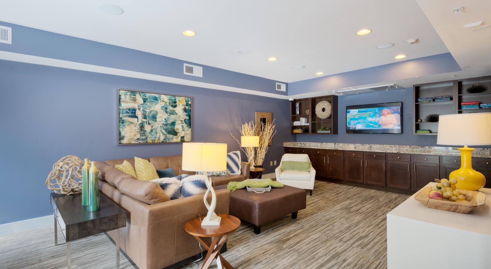 Quick access to state-of-the-art amenities a clubhouse room with a tv and couches
